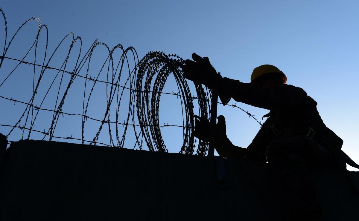 A U.S. soldier removes barbed wire from a wall at the Bagram air base in Afghanistan on Nov. 1 as the United States prepared to leave the base.