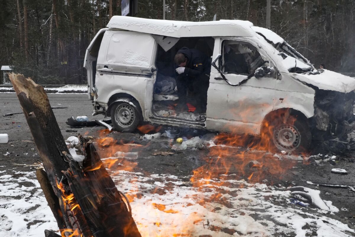 A man reacts inside a vehicle damaged by shelling, in Brovary, outside Kyiv, Ukraine, Tuesday, March 1, 2022. Russian shelling pounded civilian targets in Ukraine's second-largest city again Tuesday and a 40-mile convoy of tanks and other vehicles threatened the capital — tactics Ukraine's embattled president said were designed to force him into concessions in Europe's largest ground war in generations. (AP Photo/Efrem Lukatsky)