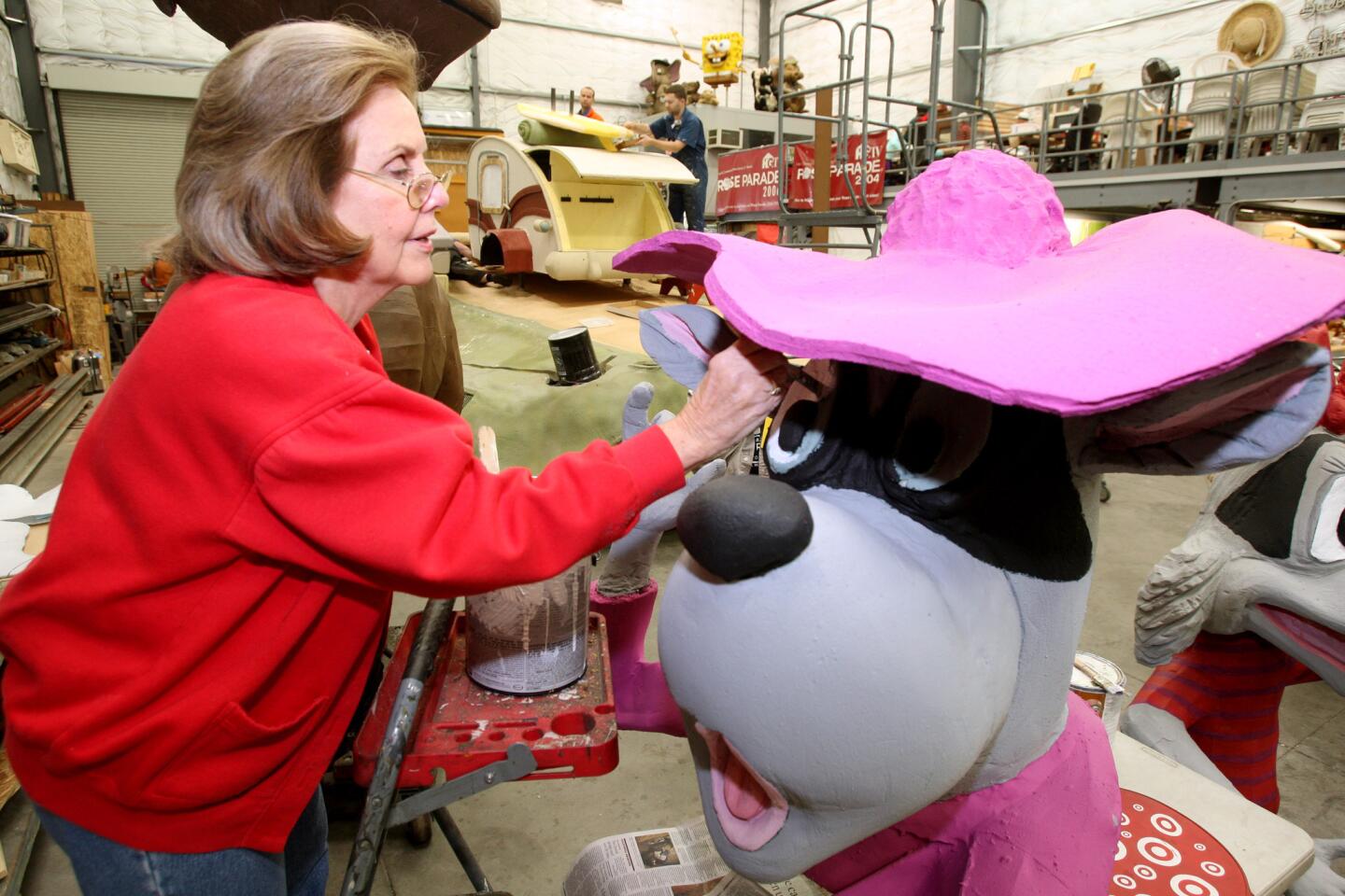 Ginny Meyers paints the mother raccoon character for the Burbank Tournament of Roses Assn.'s float at the construction site in Burbank on Saturday, Dec. 26, 2015. Meyers has been volunteering at this location on and off since 1963. The float's theme this year is "Are We There Yet?"