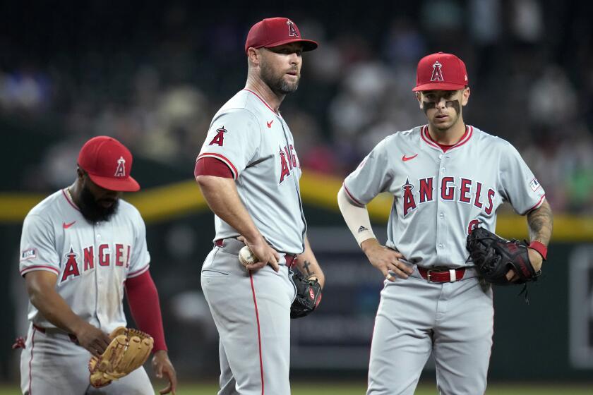 Los Angeles Angels relief pitcher Hunter Strickland, center, pauses on the mound.