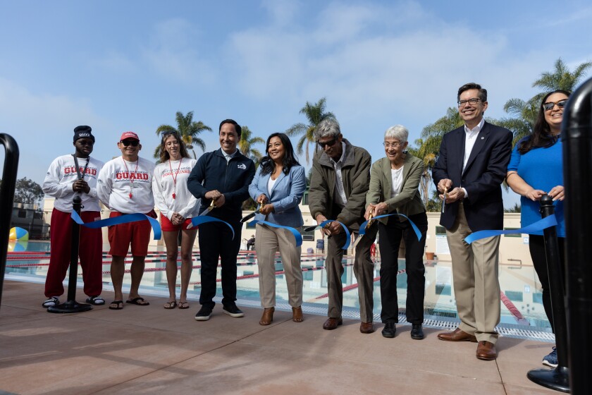 Mayor Todd Gloria, fourth from left, cuts a ceremonial ribbon 