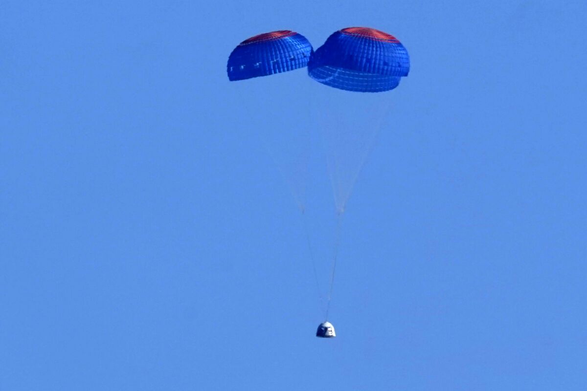 Parachutes slow the descent of the Blue Origin capsule upon its return to Earth.