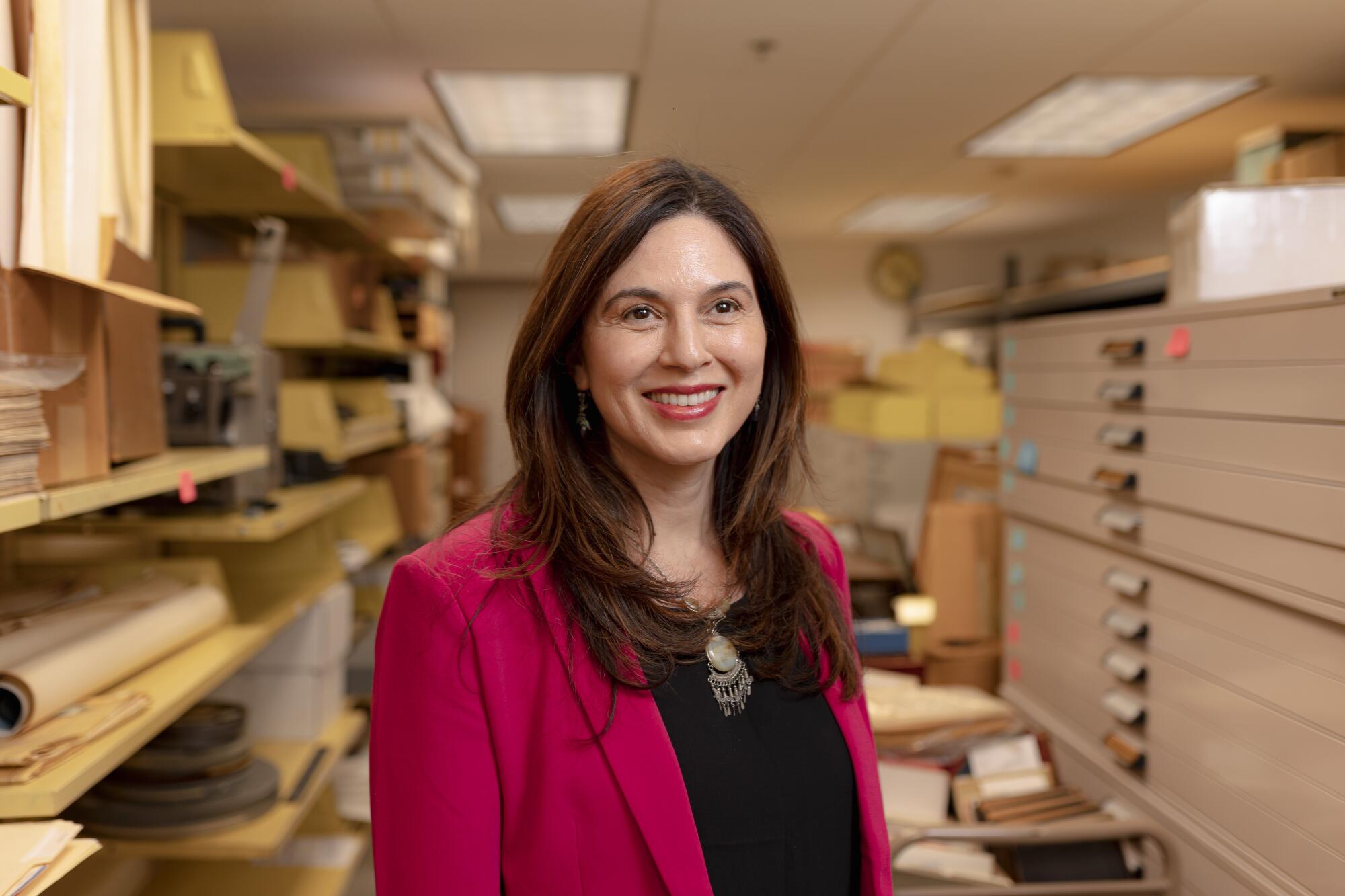 Gabriela Nuñez stands inside a library's archival multimedia collection