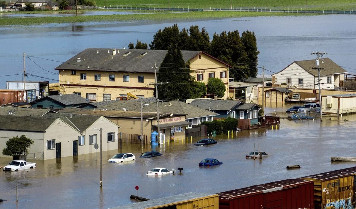 Las aguas de las inundaciones rodean viviendas y vehículos en la comunidad de Pájaro, en el condado de Monterey. 