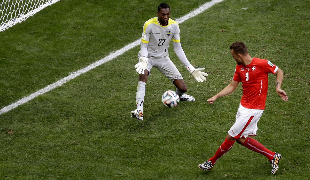 Switzerland forward Haris Seferovic sends a shot past Ecuador goalkeeper Alexander Dominguez in stoppage time to clinch a 2-1 victory in a World Cup Group E game Sunday at the Estadio Nacional in Brasilia, Brazil.