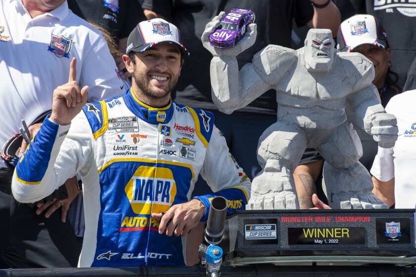 Chase Elliott gestures next to his trophy after a NASCAR Cup Series auto race at Dover Motor Speedway, Monday, May 2, 2022, in Dover, Del. (AP Photo/Jason Minto)