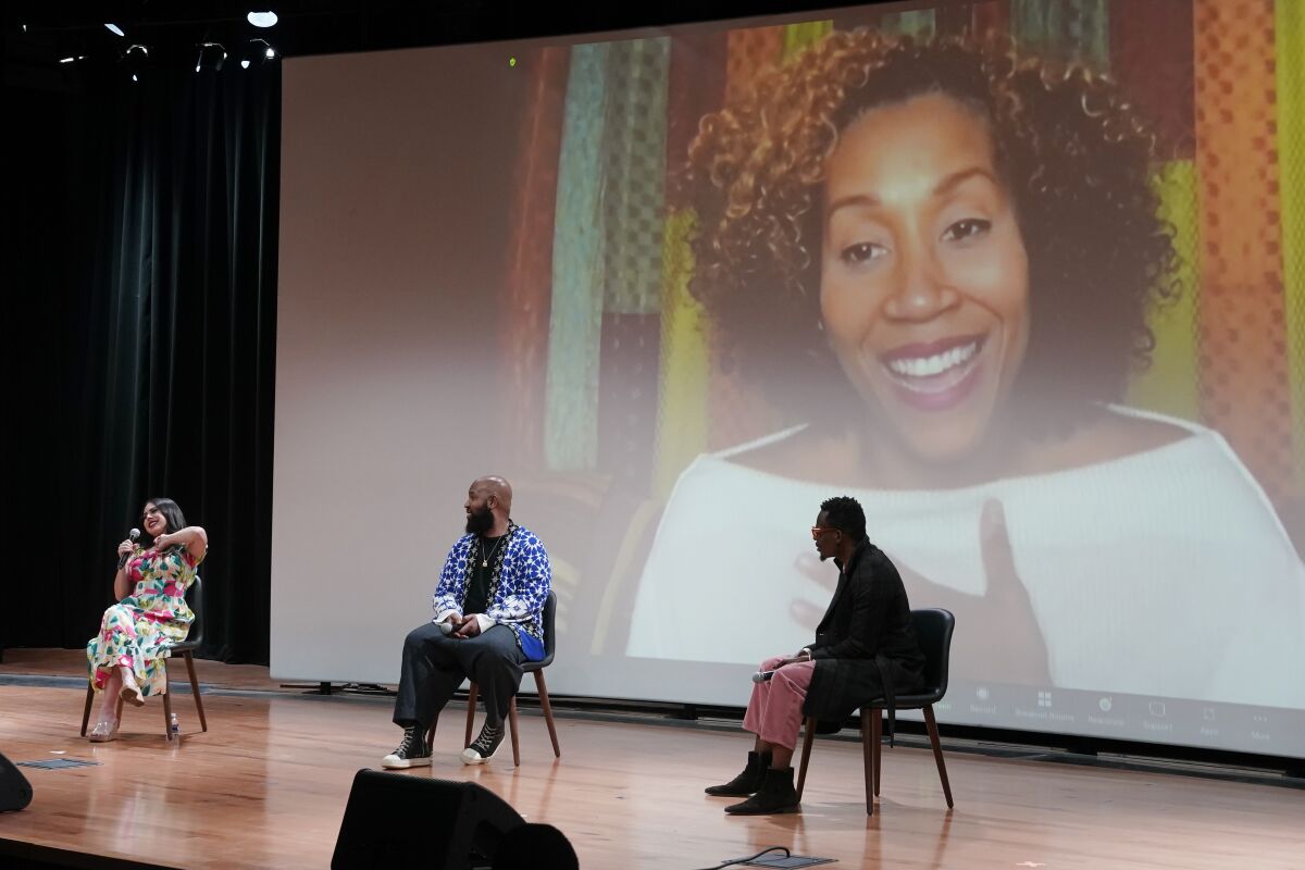 Valerie Ponzio, from left, Claude Kelly, and Chuck Harmony take part in a discussion moderated by Rissi Palmer, on screen, during the Rosedale Summit at the National Museum of African American Music Monday, Nov. 8, 2021, in Nashville, Tenn. The Rosedale Summit brought artists, academics and historians together to address racial representation within the genre of country music. (AP Photo/Mark Humphrey)