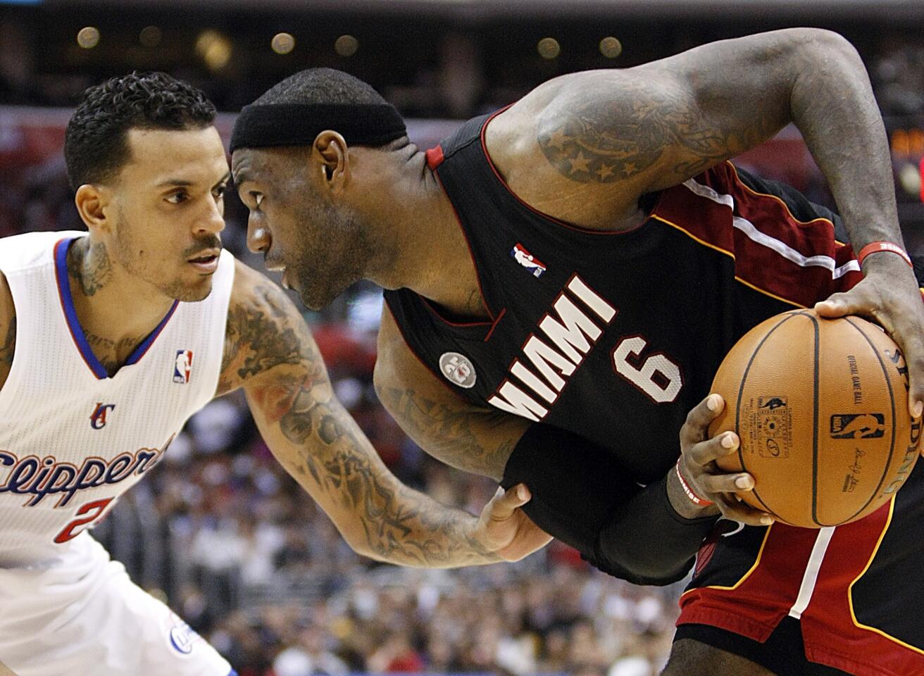 Clippers forward Matt Barnes plays tight defense on Heat forward LeBron James during their game Wednesday night at Staples Center.