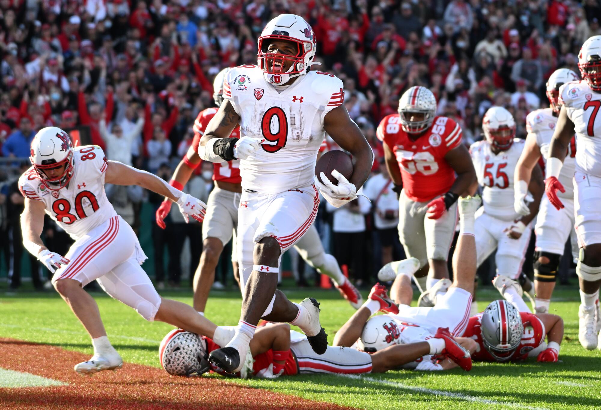 Utah running back Tavion Thomas smiles as he runs for a touchdown.