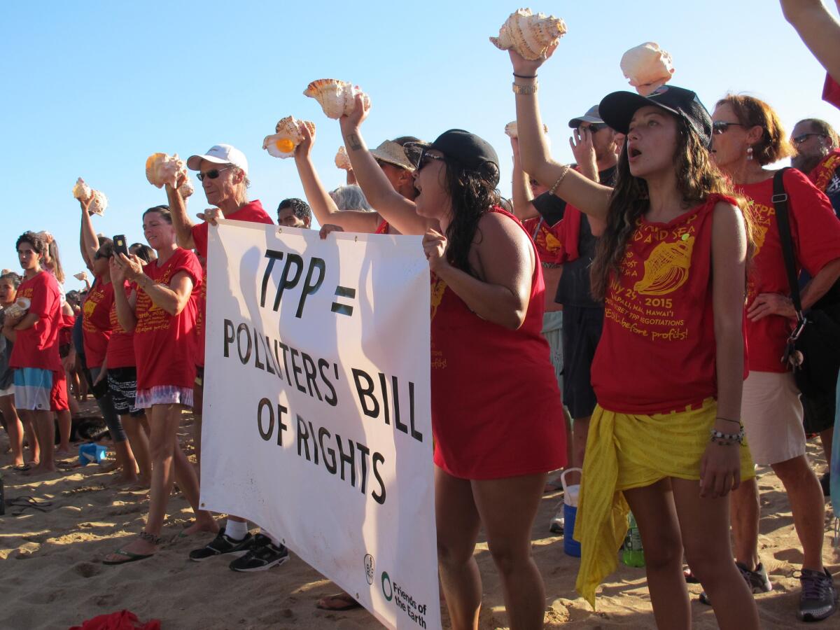 Protesters holding conch shells line Kaanapali Beach in Lahaina, Hawaii, at a rally against the Trans-Pacific Partnership.
