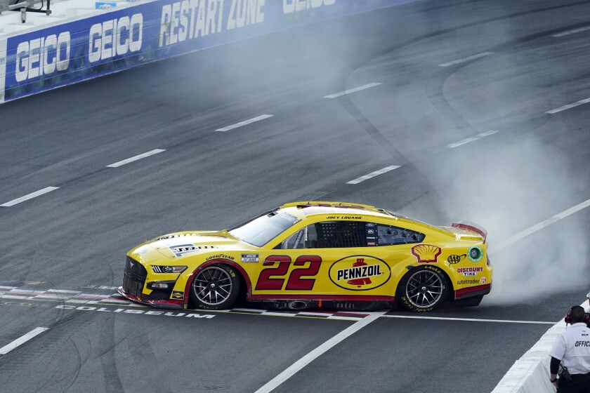 Joey Logano does a burnout at the start/finish line after winning the Busch Light Clash at the Coliseum.