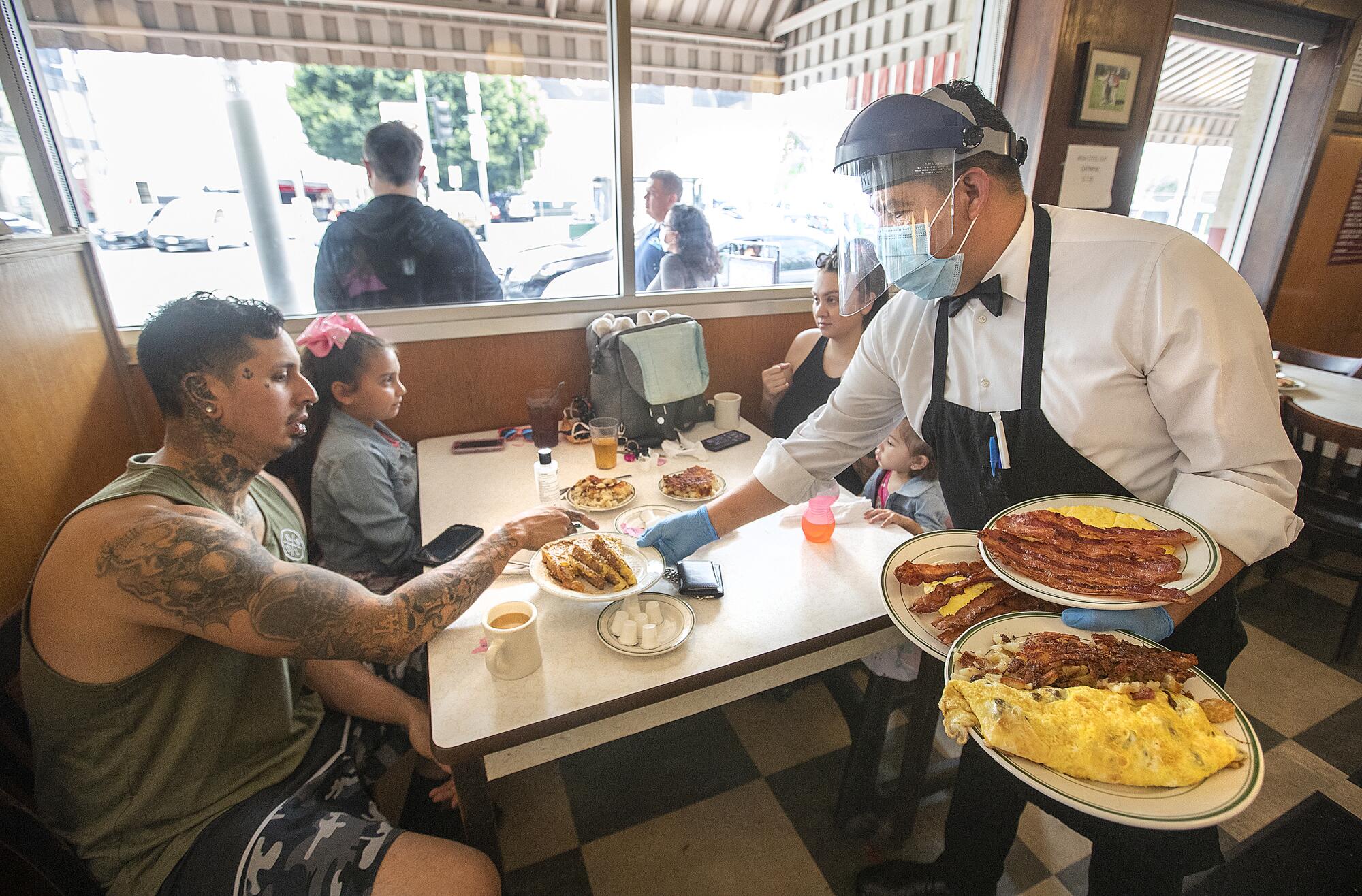 Jesus Segura, right, serves customers at the Original Pantry in downtown Los Angeles on Wednesday.