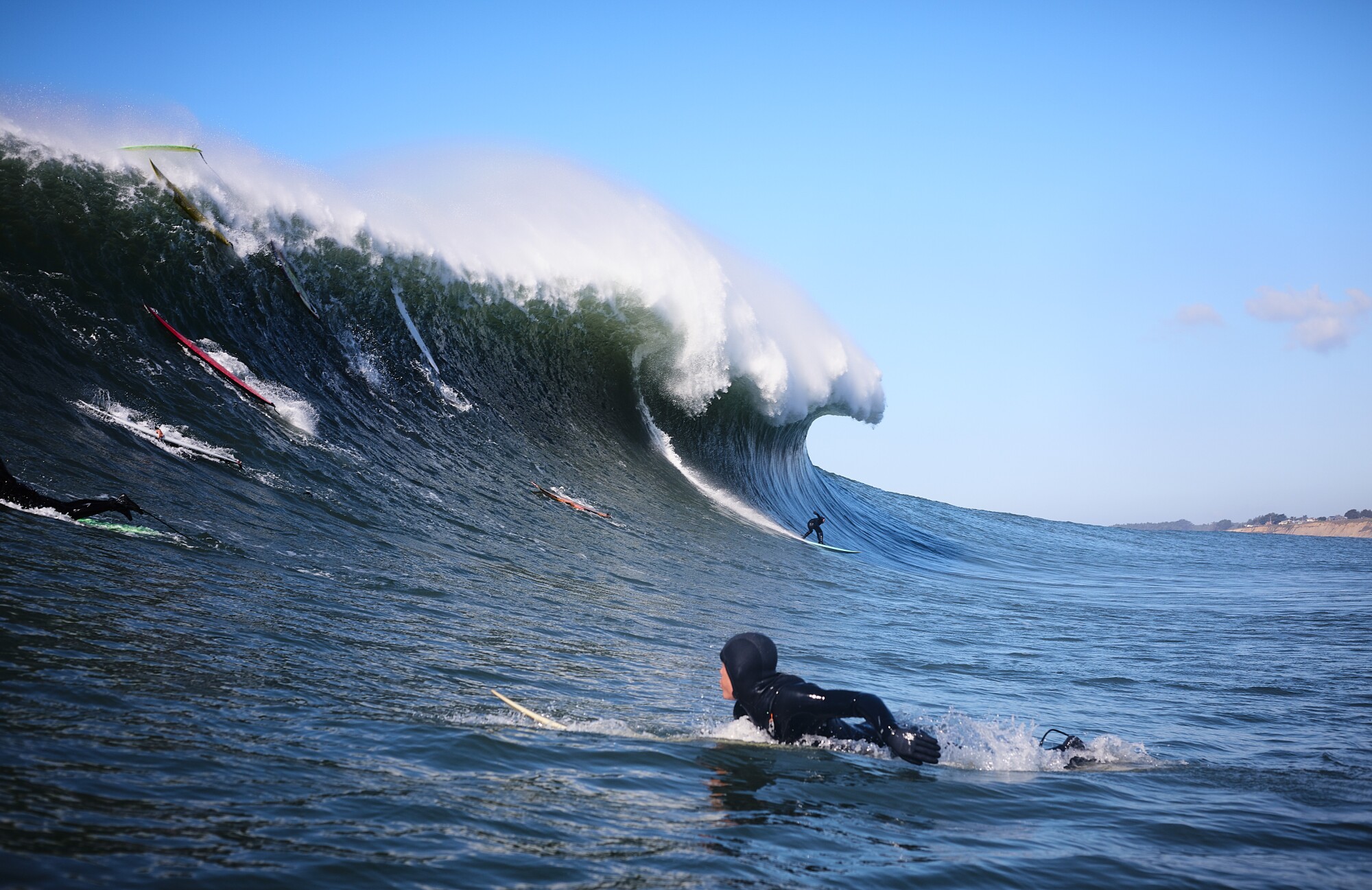 Eine Reihe von Surfern auf einer Welle von über 20 Fuß