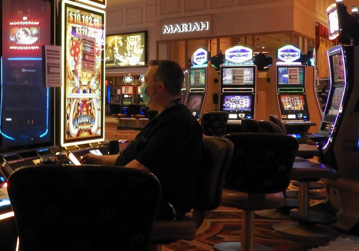 Technician Scott Trickler upgrades slot machines at Caesars' Vegas casino before its reopening.