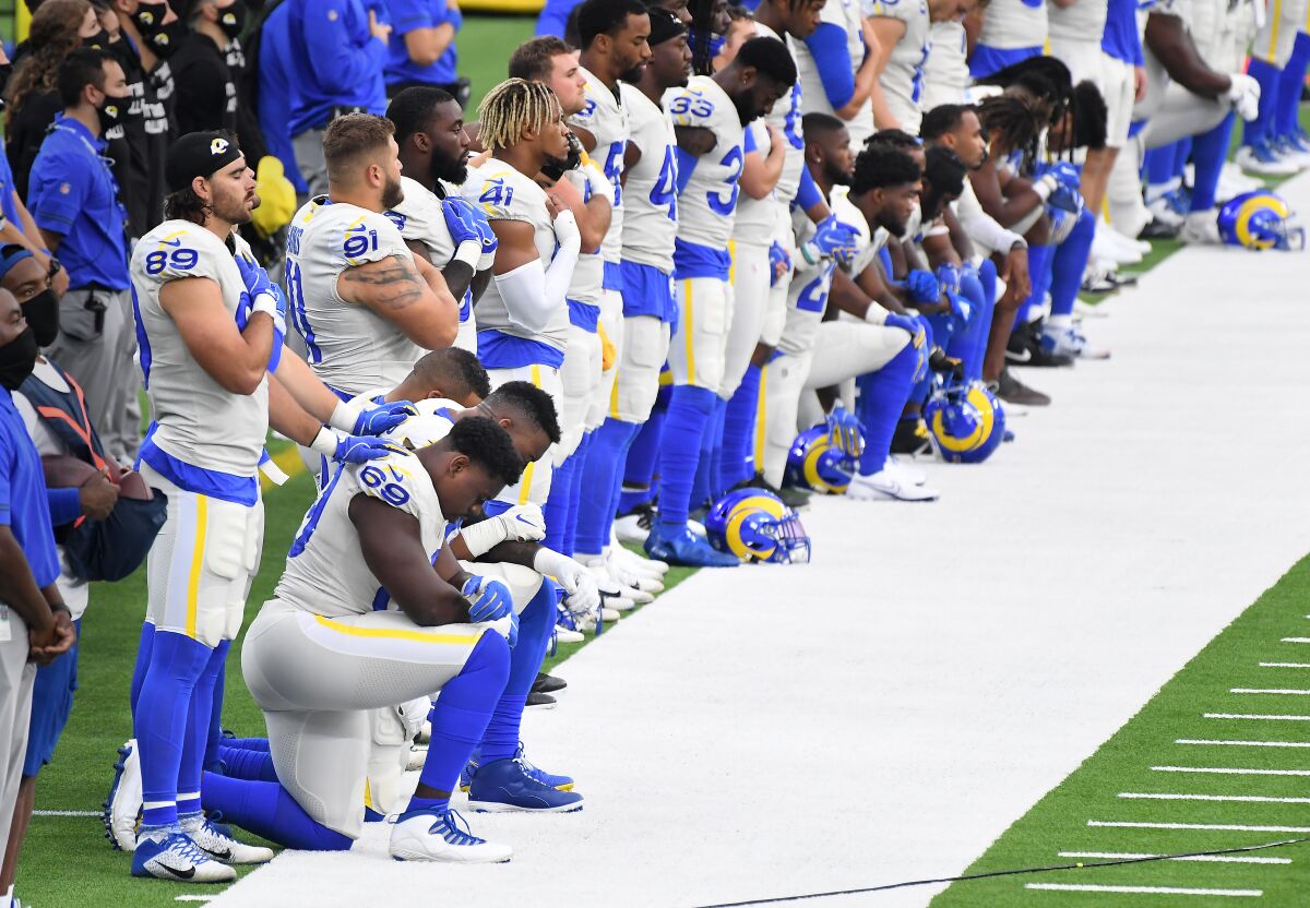 Players on the Rams kneel and stand during the national anthem at SoFi Stadium in Inglewood on Sunday.