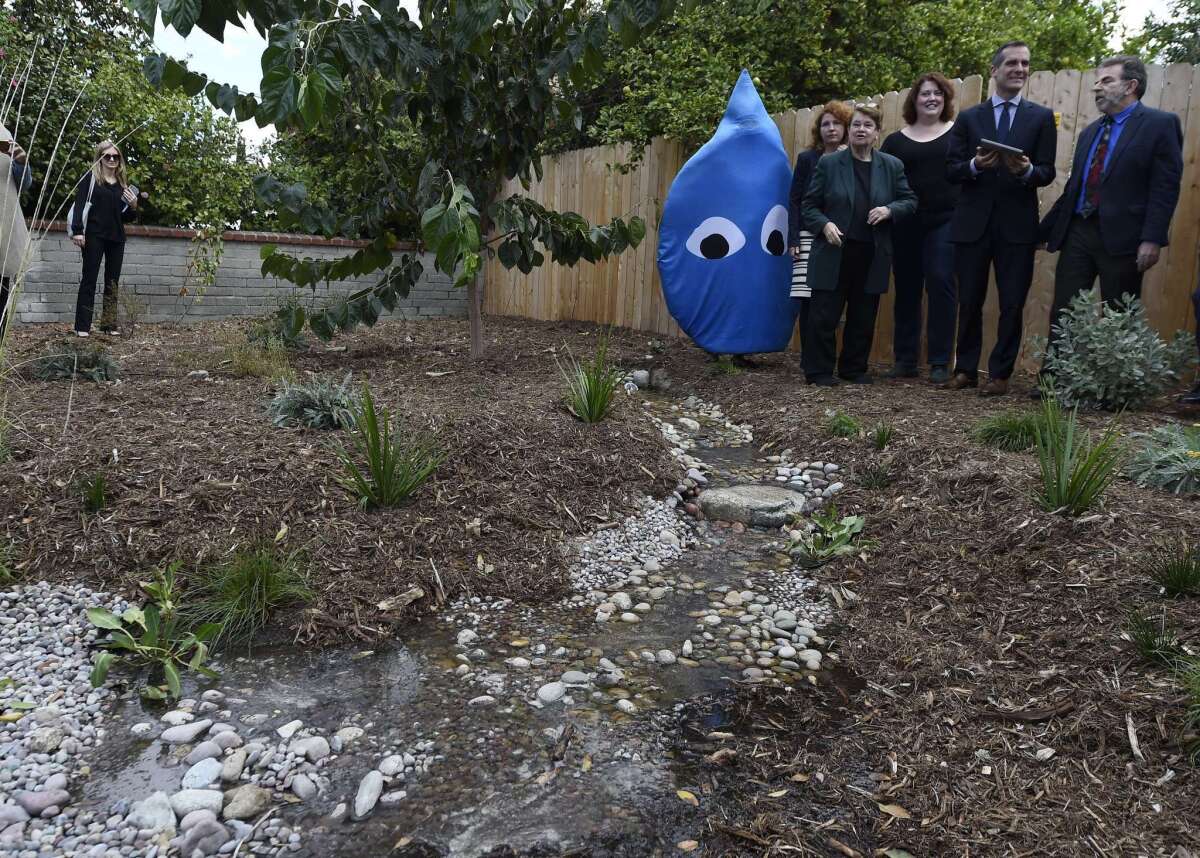 L.A. County Supervisor Sheila Kuehl, Mayor Eric Garcetti and conservation advocate Andy Lipkis of TreePeople stand with others and watch as water is released electronically from a newly installed 500 liter water cistern into a "rain garden" for replenishing groundwater on Nov. 4.