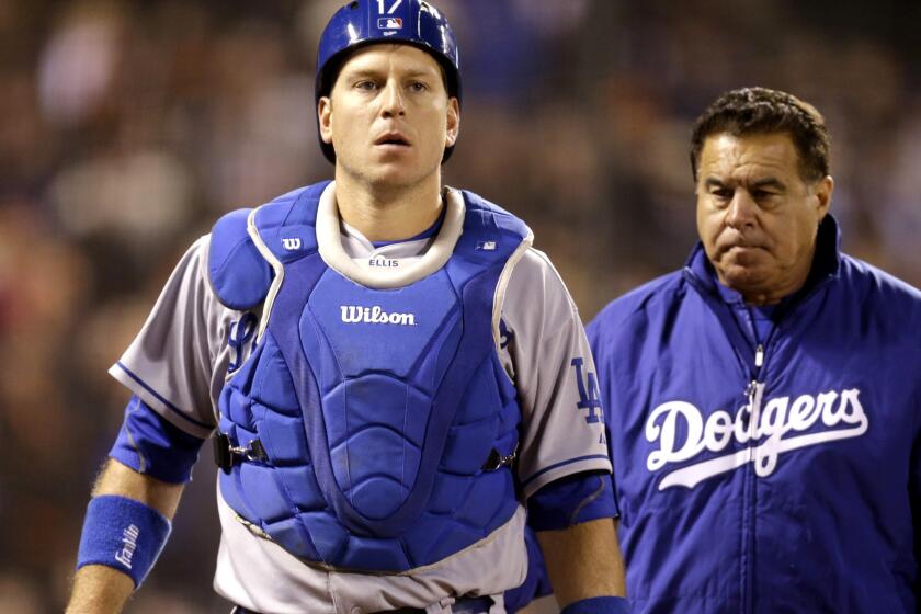 Dodgers catcher A.J. Ellis leaves the field after taking a foul ball off his throwing hand in the ninth inning of an April 22 game against the Giants in San Francisco.