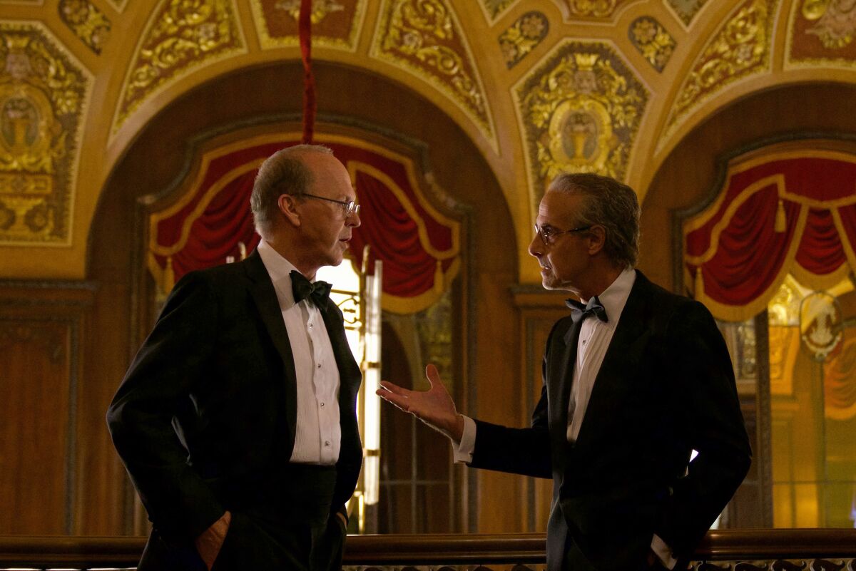 Two men in formal wear talk in the movie “Worth.”