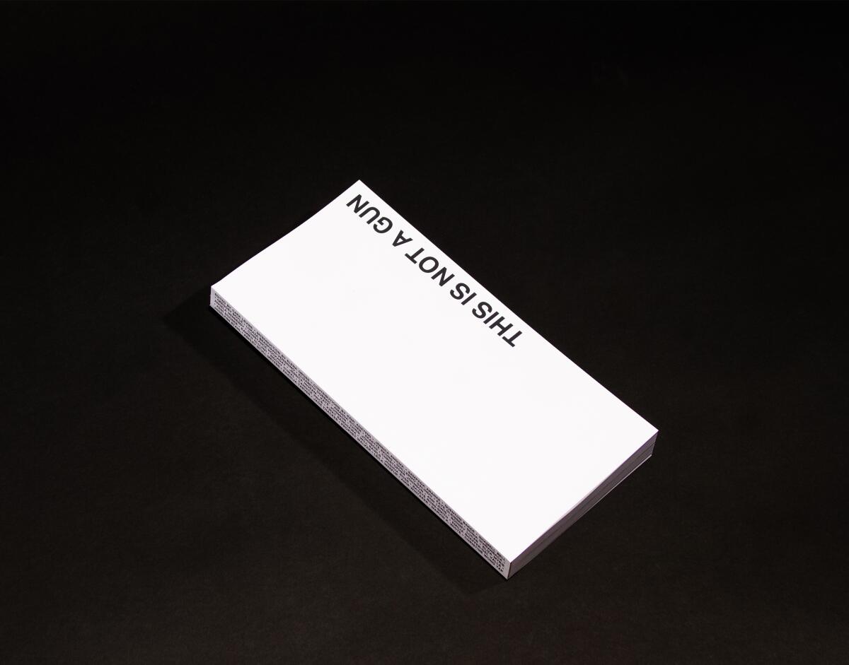 The book "This Is Not a Gun" — produced all in white — is shown against a stark black background.
