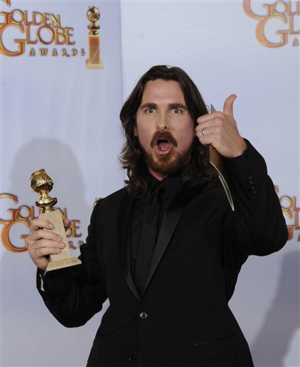 Christian Bale holds up his trophy for Best Performance by an Actor in a Supporting Role in a Motion Picture for his role in "The Fighter," during the Golden Globe Awards Sunday, Jan. 16, 2011, in Beverly Hills, Calif. (AP Photo/Mark J. Terrill)