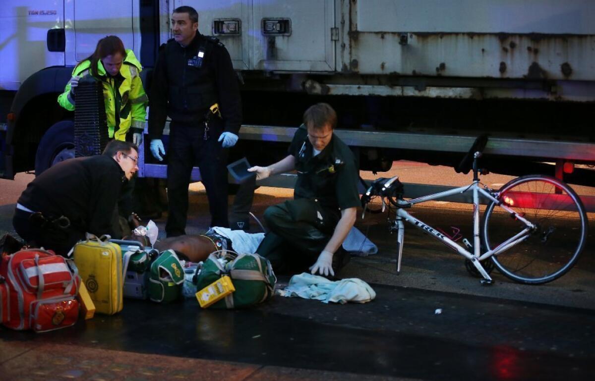 A cyclist receives emergency medical treatment after being involved in a collision with a truck this week in London.