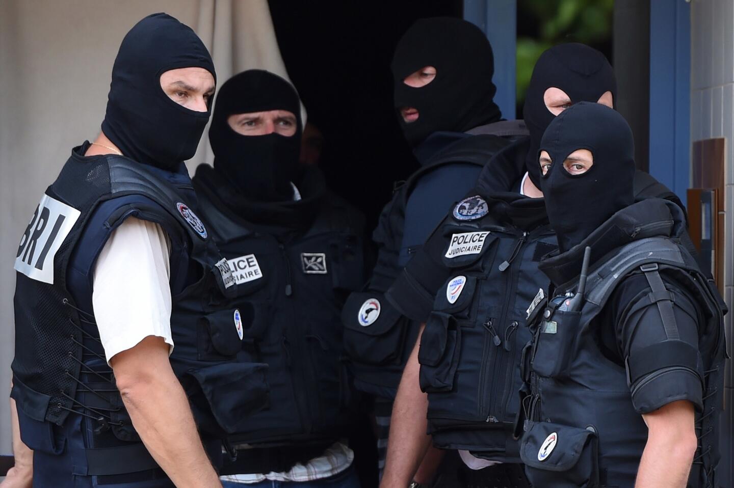 Members of a French special forces team in Saint-Priest, France, stand outside the apartment of a man suspected of carrying out an attack near Lyon.