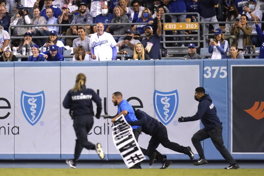 A fan who made his way on to the field is tackled by security personnel during a Diamondbacks Dodgers game