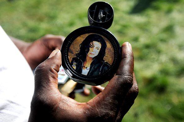 Wyatt Puryear of Gary, Indiana, holds an autographed bottle of Michael Jackson cologne in the front yard of the singer's childhood home.