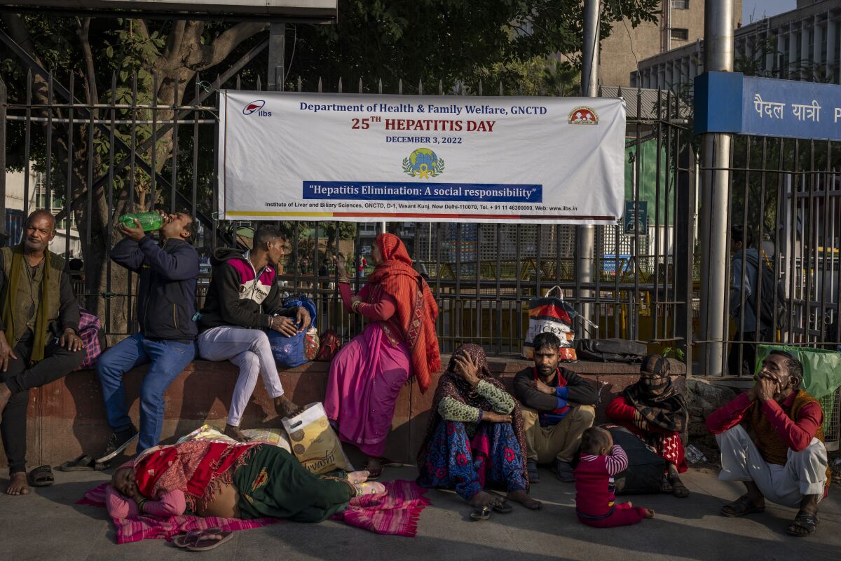 Patients and their attendants squat outside the All India Institute of Medical Sciences (AIIMS) hospital in New Delhi, India, Wednesday, Dec. 7, 2022. The leading medical institute in India's capital limped back to normality on Wednesday after a cyberattack crippled its operations for nearly two weeks. (AP Photo/Altaf Qadri)