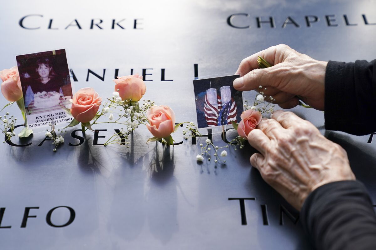 Mourners place flowers and pictures at the National September 11 Memorial and Museum