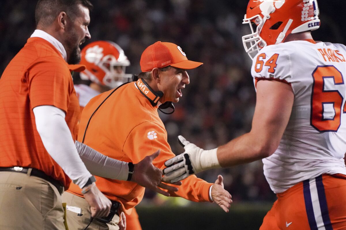 Clemson head coach Dabo Swinney congratulates players after a score during the first half of the team's NCAA college football game against South Carolina on Saturday, Nov. 27, 2021, in Columbia, S.C. (AP Photo/Sean Rayford)