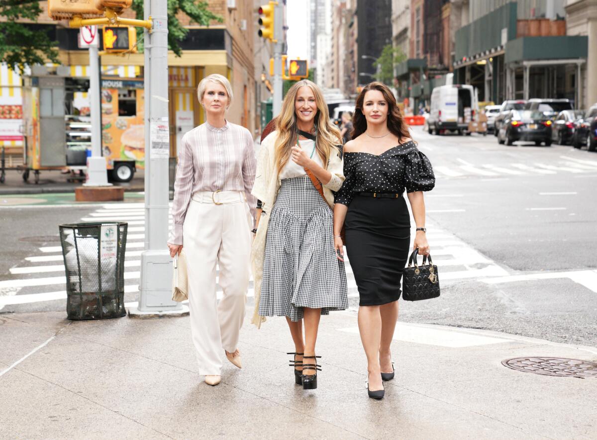 Three stylish women stroll down a New York City street