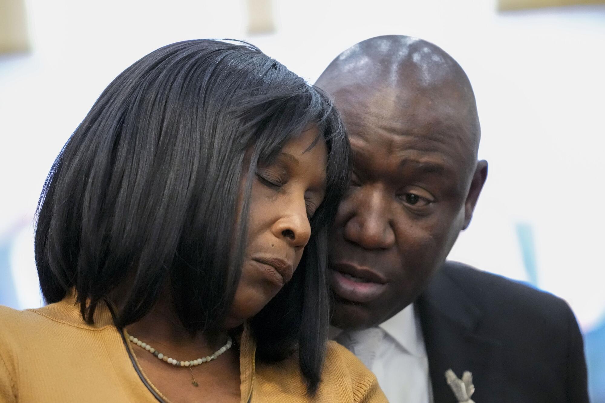 A closeup of a woman with her eyes closed, leaning into a man as he speaks to her