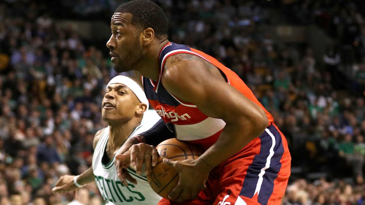 Celtics guard Isaiah Thomas tries to steal the ball from Wizards guard John Wall during a game in Boston on March 20.