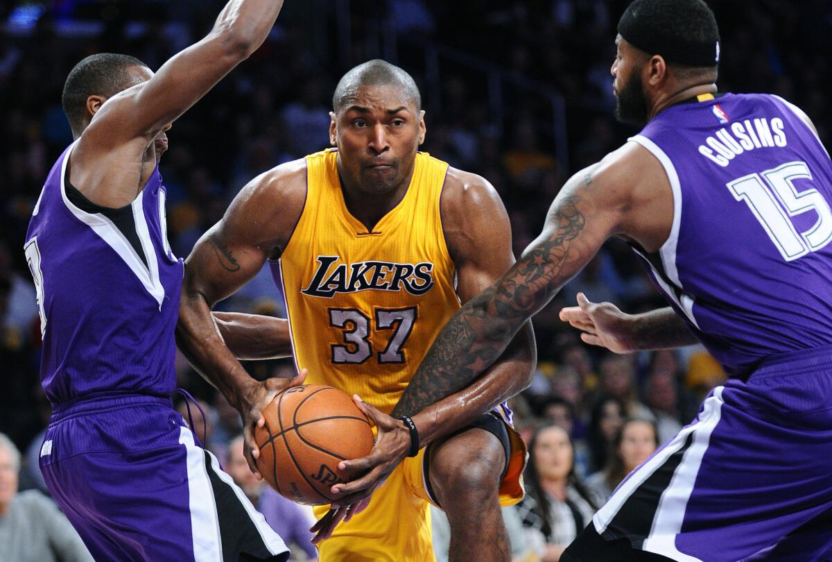 Lakers' Metta World Peace drives between Sacramento's Rajon Rondo, left, and DeMarcus Cousins on March 15.