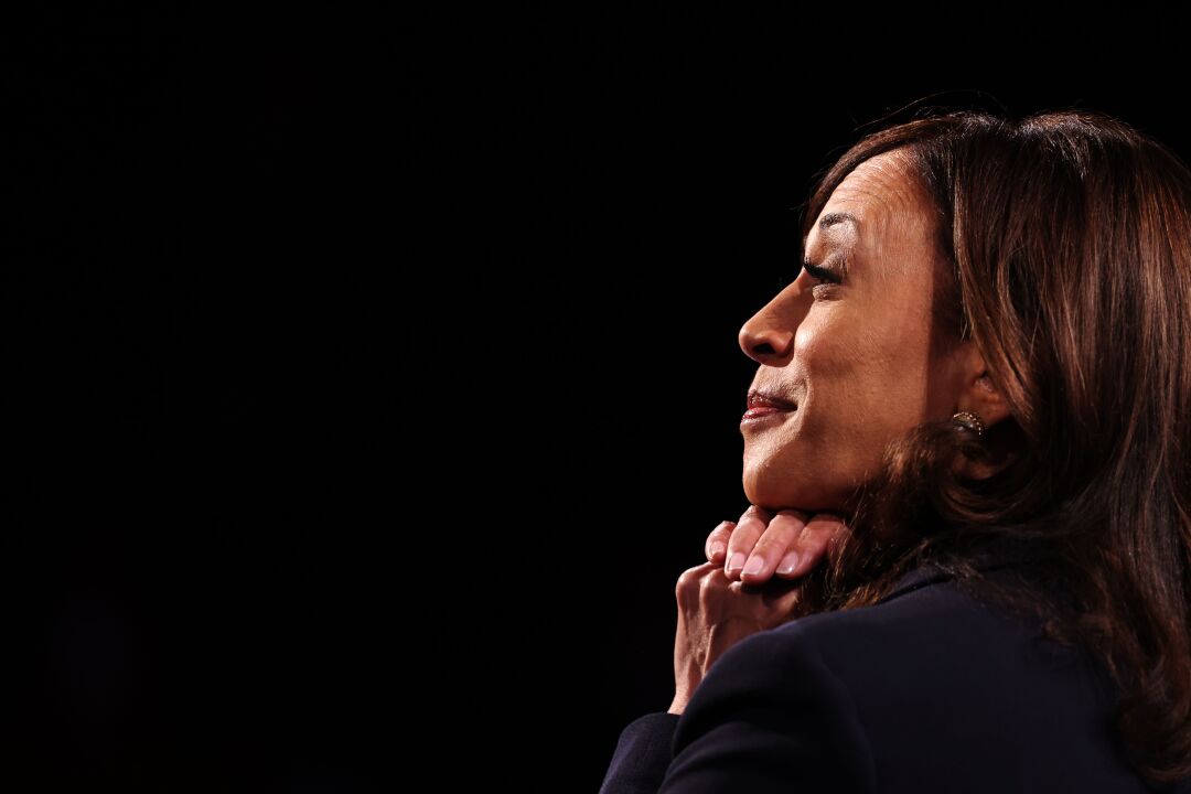 Kamala Harris smiles and places her hands under her chin