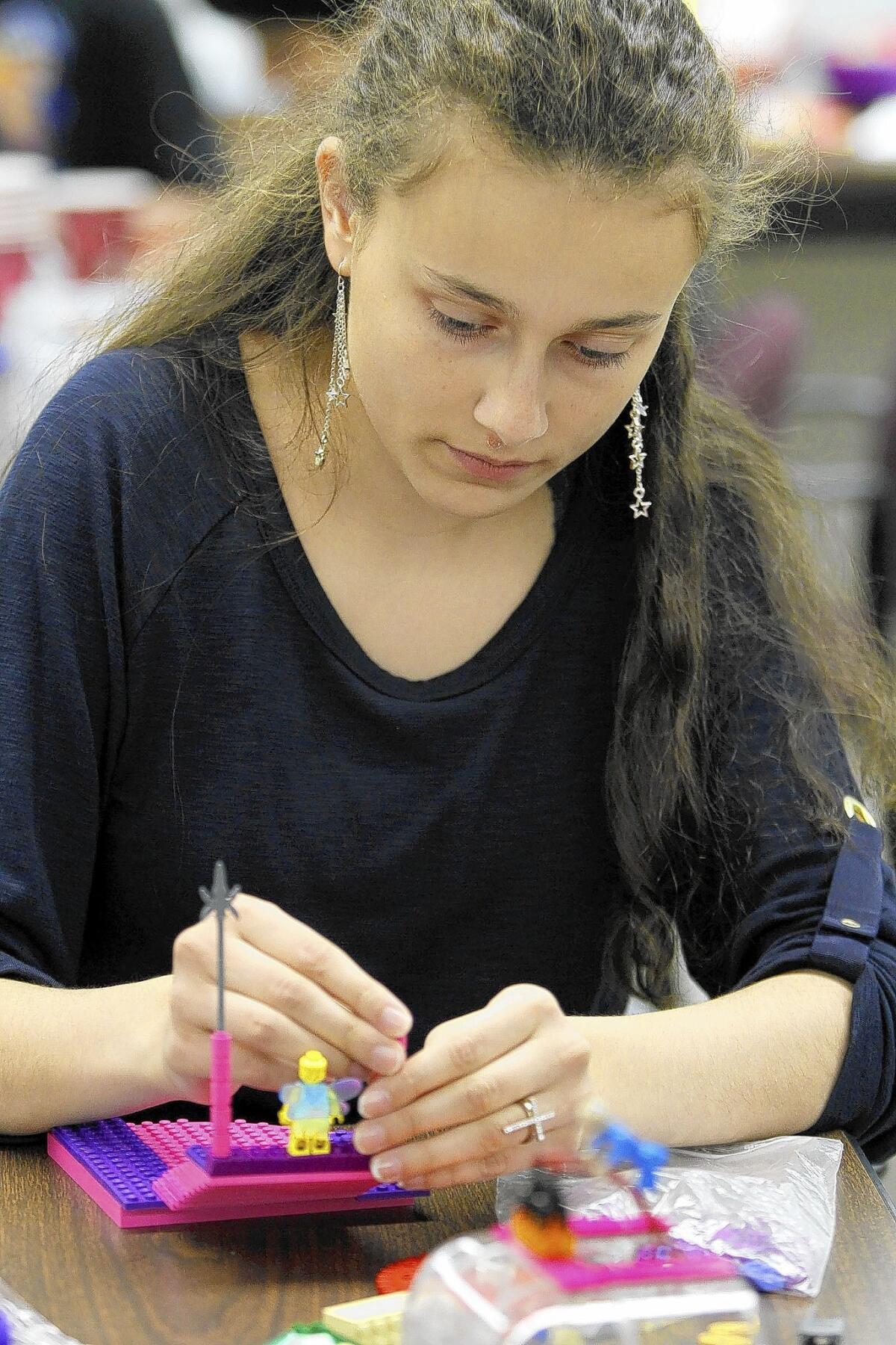 Antonia Nituleasa, 16 of Burbank, works on an out-of-this-world creation at the Sc- Fi Legos event at the Burbank Central Library in Burbank on Tuesday, July 1, 2014. The youth in attendance got to make an alien, a robot or a spaceship out of the blocks, then made short videos using the LEGO creations with the help of Peter Abrahamson and Brandon Griffiths.