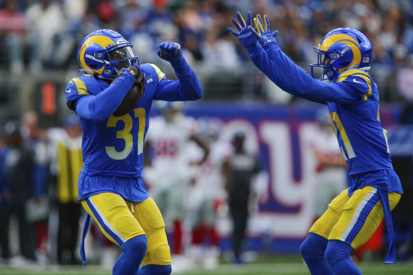 Los Angeles Rams' Robert Rochell, left, celebrates his interception during the first half of an NFL football game against the New York Giants, Sunday, Oct. 17, 2021, in East Rutherford, N.J. (AP Photo/Frank Franklin II)