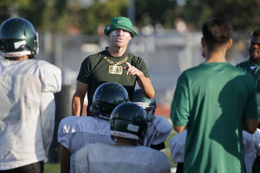 Costa Mesa High new head coach Jimmy Nolan, center, speaks to his players during practice on Monday at Costa Mesa High.