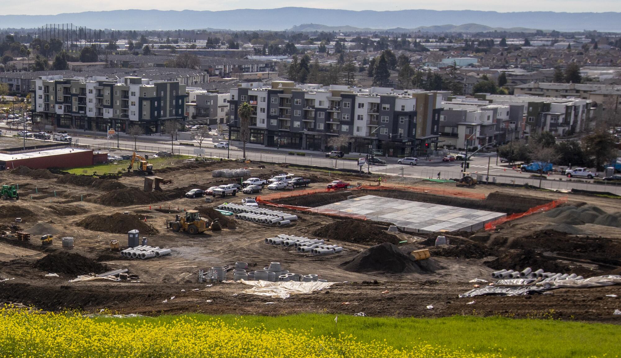 In the background, a new development project is under construction on former Caltrans-owned land in Hayward. 