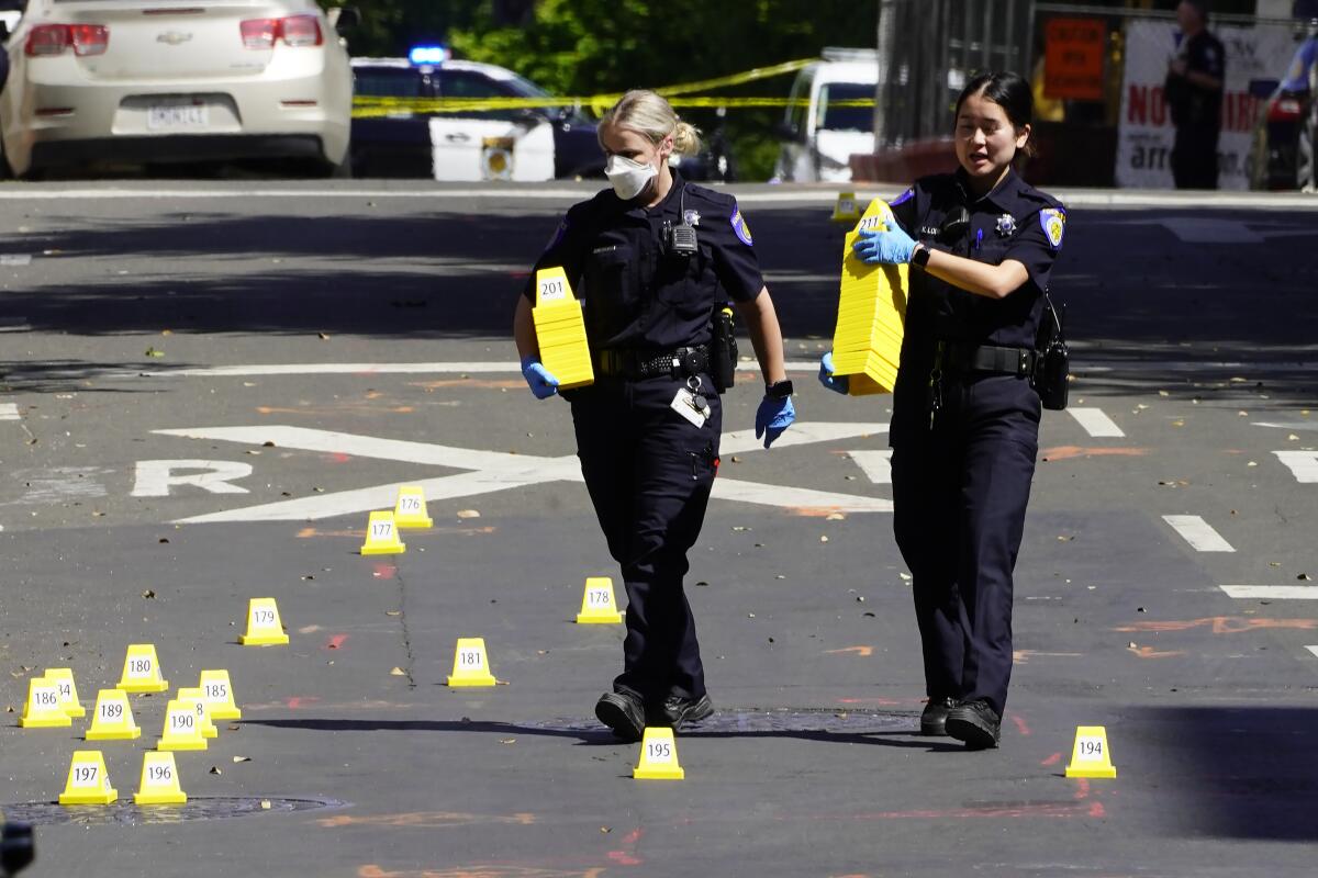 Sacramento police carry evidence markers at the scene of a shooting this month.