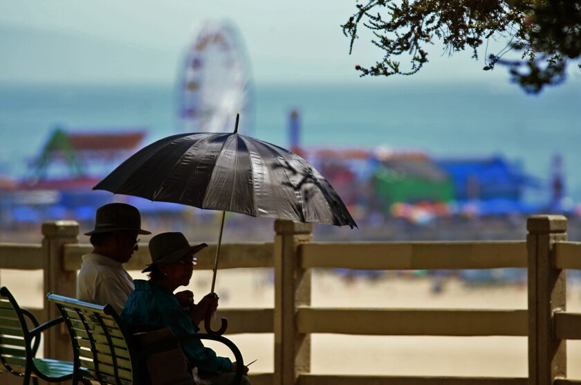 A couple sits under the shade of an umbrella in Palisades Park in Santa Monica in September 2015. The Santa Monica City Council voted Tuesday to raise the city's minimum wage.