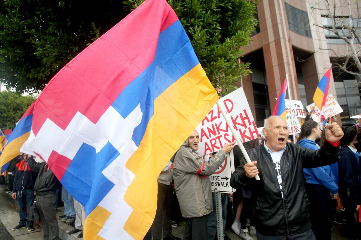 Norik Bedrossian of Glendale waves a flag and chants during a rally outside the Azerbaijan Consulate in Los Angeles on Friday, April 8, 2016. A few thousand people chanted and held signs on the 11,700 bock of Wilshire Blvd., where the consulate offices are located, over recent attacks attacks on ethnic Armenians living in the Nagorno-Karabakh Republic.