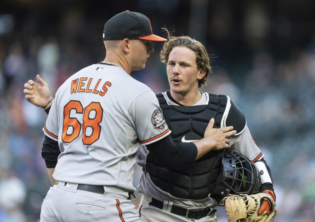 Baltimore Orioles starting pitcher (68) is congratulated by catcher Adley Rutschman after the second inning of a baseball game against the Seattle Mariners, Monday, June 27, 2022, in Seattle. (AP Photo/Stephen Brashear)