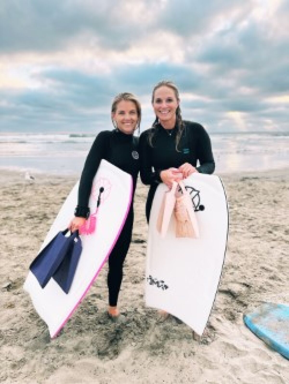 Cristi Turvey, left, and Lauren Bennett, right, started a boogie boarding club for mothers, called "Boogie Moms."