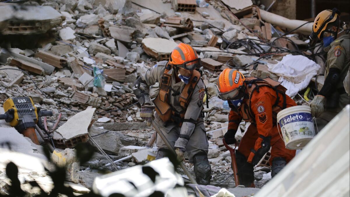 Firefighters search for survivors April 13 amid the debris of two buildings that collapsed the previous day in the Muzema neighborhood of Rio de Janeiro.