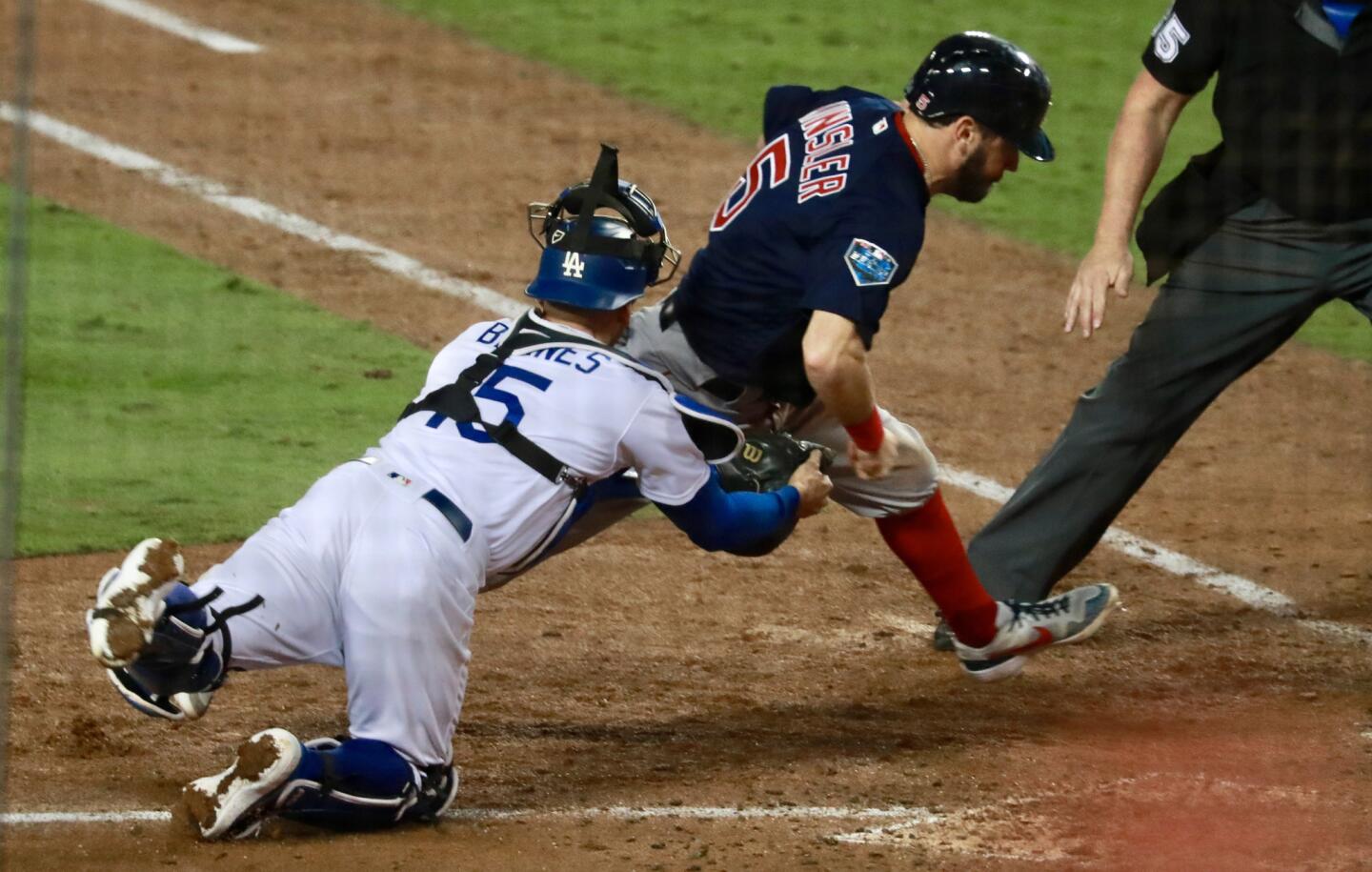 Red Sox's Ian Kinsler is tagged out by Los Angeles Dodgers' Austin Barnes at home plate while trying to score on a sacrifice fly by Eduardo Nunez during the 10th inning.