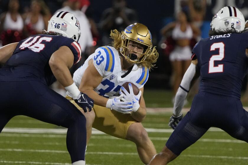 UCLA running back Carson Steele (33) tries to get past Arizona defensive lineman.