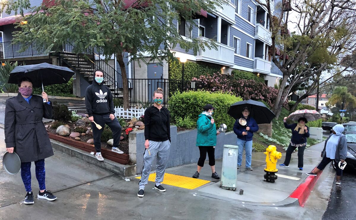 Neighbors in and around the Parkside Apartments in North Park gathered Monday evening for their minute of noise-making to honor the hard work of healthcare workers.