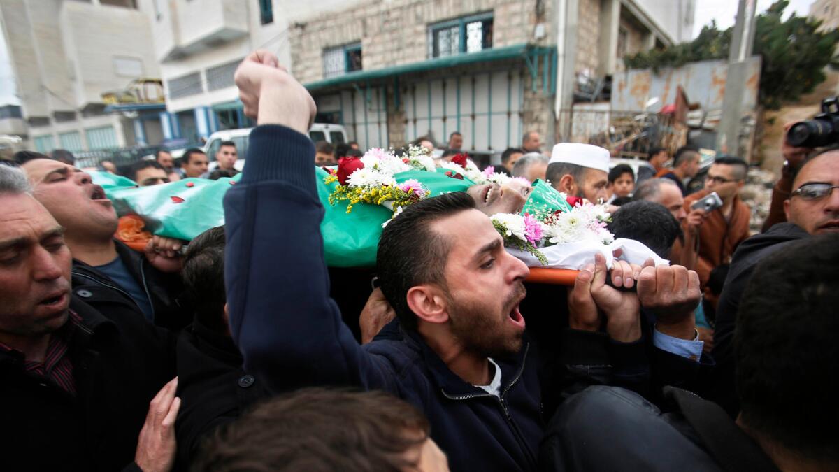 Palestinians carry the body of Abdel Fattah Sharif, who was shot to death by an Israeli soldier, during his funeral in the West Bank city of Hebron on May 28.